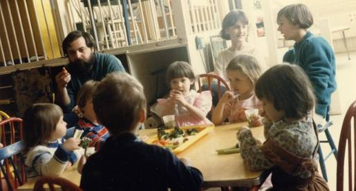 children and adults sitting around a table eating snacks